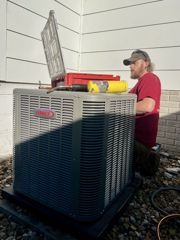 A tech installing a new air conditioner